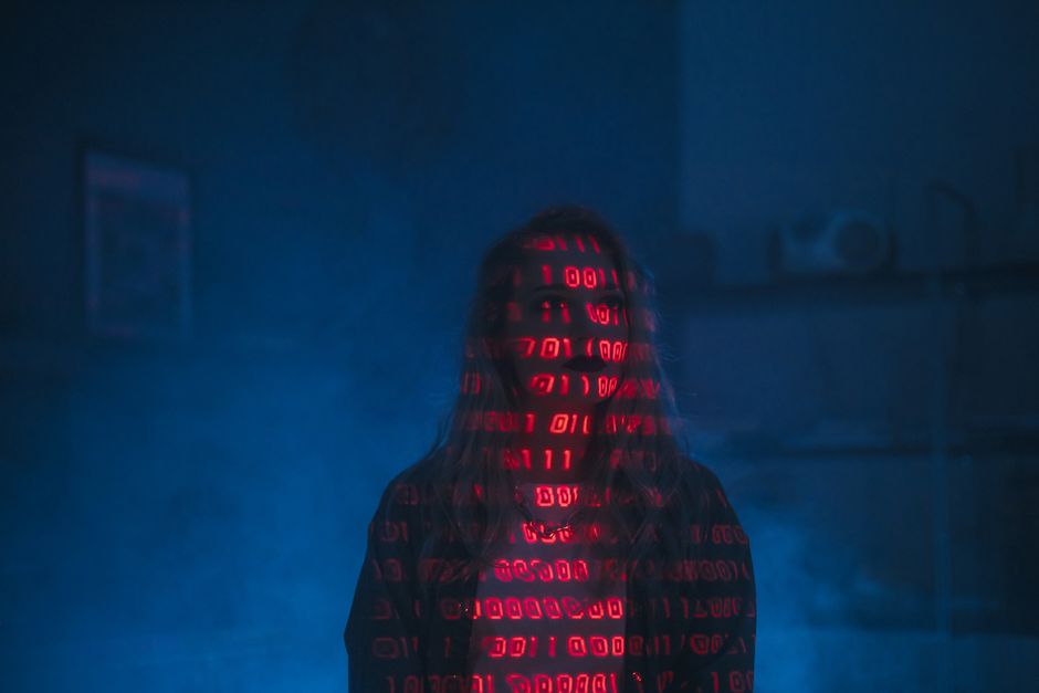 A close-up view of a modern laptop displaying lines of computer code on the screen. The screen shows a programming interface with syntax highlighting, including variables and functions related to soft